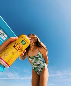 a woman in a bathing suit holding a can of coffee