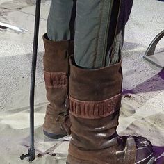 a pair of boots with ski poles attached to the legs and feet, on display