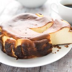 a piece of cheesecake on a plate next to a cup of coffee