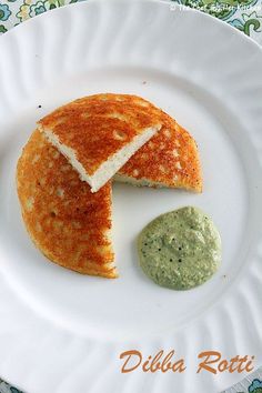 a white plate topped with a piece of bread and a green substance next to it