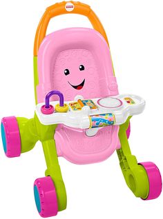 a pink and green baby walker with wheels on the handlebars, smiling at the camera