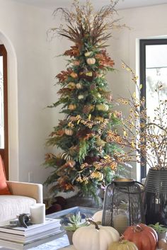 a living room filled with furniture and a christmas tree in the middle of the room