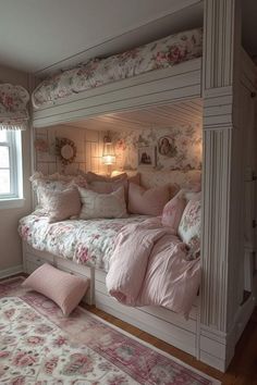 a white bunk bed sitting next to a window with pink pillows on top of it