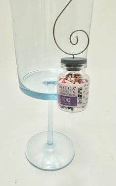 a glass with a jar on it and a wire in the bottom that holds candy