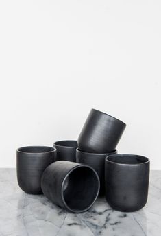 five black vases stacked on top of each other