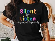 a woman wearing a black t - shirt with the words silent and listen on it