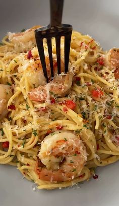 a fork is stuck in some pasta with shrimp