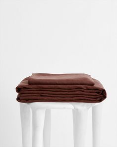 three white stools with folded brown sheets on each one, all in different positions