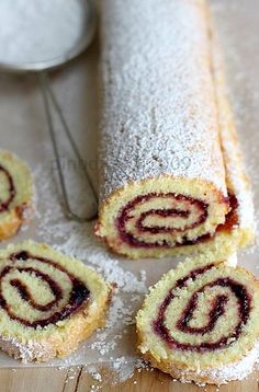 some type of pastry on a table with powdered sugar next to it and a spoon