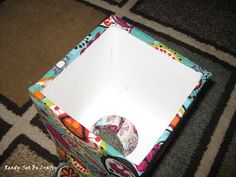 an open box sitting on top of a carpeted floor next to a black and white rug