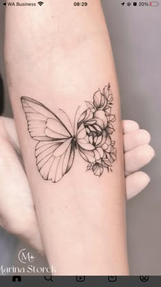 a woman's arm with a butterfly and flower tattoo on the left side of her arm