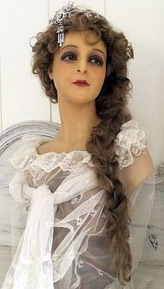 a mannequin wearing a white dress and headpiece with hair in the shape of an angel