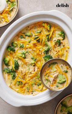 broccoli and cheese soup in a white bowl on a table with two plates