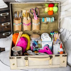 an open suitcase filled with crafting supplies