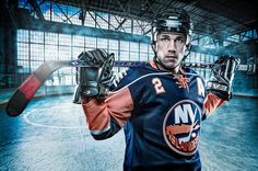 an ice hockey player is holding his glove and looking at the camera while posing for a photo