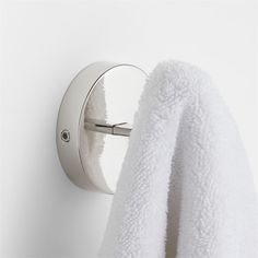 a towel is hanging on the wall next to a robe rack with an object in it