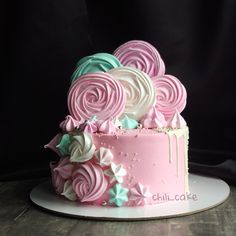 there is a pink and blue cake with swirls on the top that looks like roses