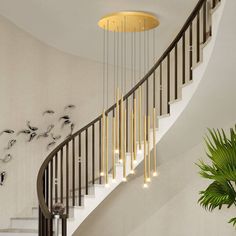 a spiral staircase with chandelier and birds on the wall next to it in a modern home