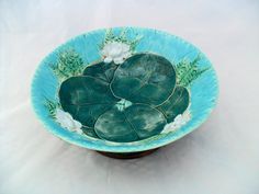 a green bowl with white flowers on it