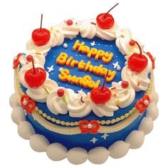 a blue birthday cake with white frosting and cherries