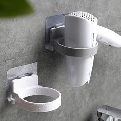 a white toilet paper dispenser mounted to the side of a gray wall