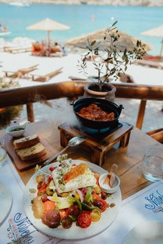 a plate of food sitting on top of a wooden table next to a bowl of fruit