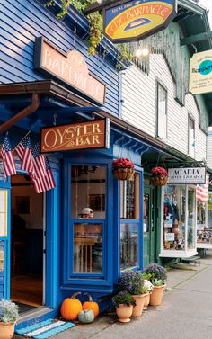 an outside view of a restaurant called oyster bar with flags hanging from the roof and potted plants in front