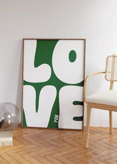 a white chair sitting next to a green and white poster on the wall in a room