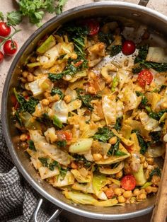 a pan filled with pasta and vegetables on top of a table