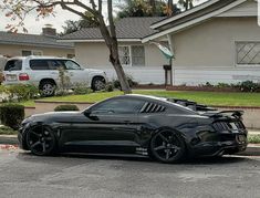 a black sports car parked in front of a house