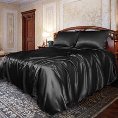 a bed with black sheets and pillows in a room