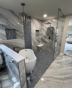 a bathroom with marble walls and flooring next to a bathtub in the middle