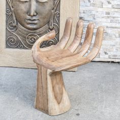 a wooden chair sitting in front of a statue