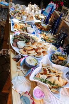 a long table filled with lots of food on top of wooden planks and plates