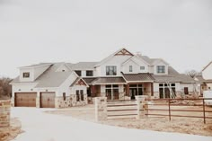 a large house with lots of windows in the front and side of it on a cloudy day