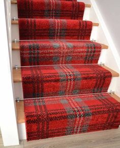 red and black plaid carpeted stairs with wooden handrails