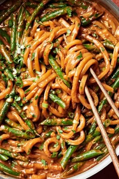 a pan filled with noodles and green beans