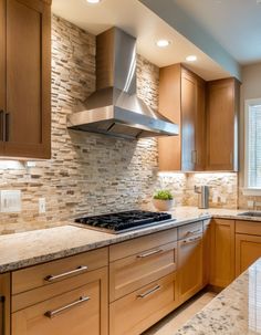 a kitchen with wooden cabinets and marble counter tops, along with a stainless steel range hood