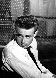 black and white photograph of a man leaning on a bench