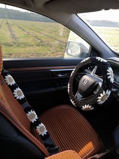 the interior of a car with a steering wheel cover and flowers on it's dashboard