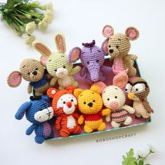 small crocheted stuffed animals sitting on top of a table next to some flowers