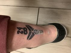 a person's foot with a tattoo on it and the number 987 written in black ink