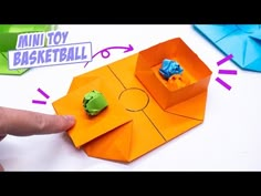 an origami box with two green and blue paper animals in it's center