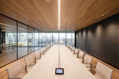 an empty conference room with chairs and a phone on the table in front of it