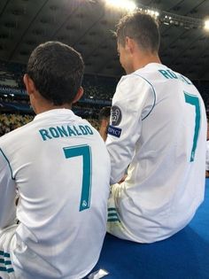 two soccer players sitting on the ground in front of an audience at a sporting event