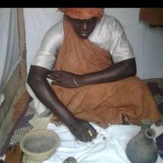 a man sitting on the floor with some pottery