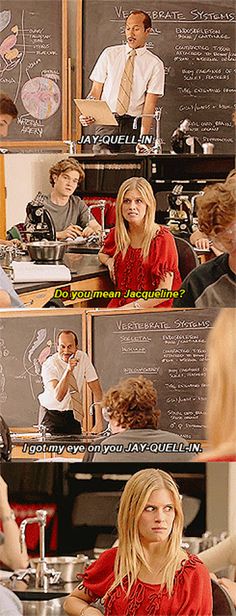 a woman sitting at a table in front of a blackboard