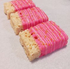 two pieces of cake with pink icing and gold sprinkles on them