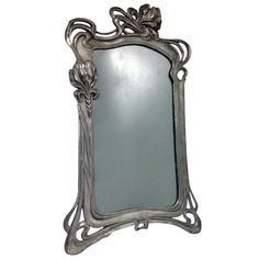 an ornate silver framed mirror on a white background