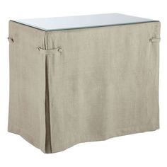 a beige table with a glass top on the front and bottom part of it's skirt